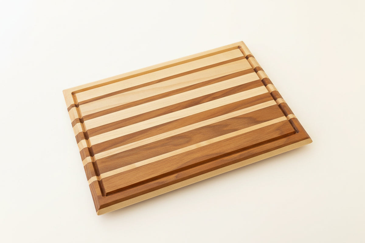 Wooden cutting board with striped pattern on a white surface